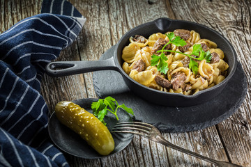 Italian pasta shells with beef sauce in cast iron pan.
