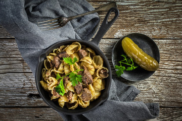 Italian pasta shells with beef sauce in cast iron pan.