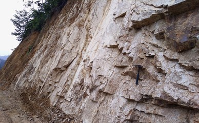 Rocks outcrop with geology hammer