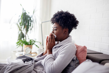 Woman lying in bed with virus and high temperature