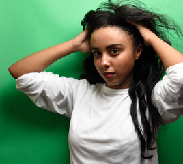 Spectacular middle eastern young woman with her black hair. Indoor photo of wonderful female model on green background.