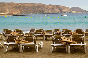 Sunbeds on Playa de Las Vistas beach in Tenerife,Canary Islands,Spain. Travel or vacation concept.Selective focus.