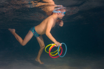 little boy in glasses for swimming bathes in the pool. Children's sport. A happy boy takes out the...