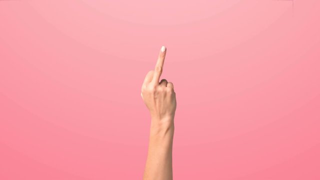 The female hand shows the middle finger. The girl raises her hand in the frame showing the middle finger and shaking it