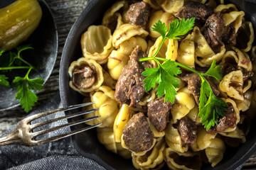 Italian pasta shells with beef sauce in cast iron pan.