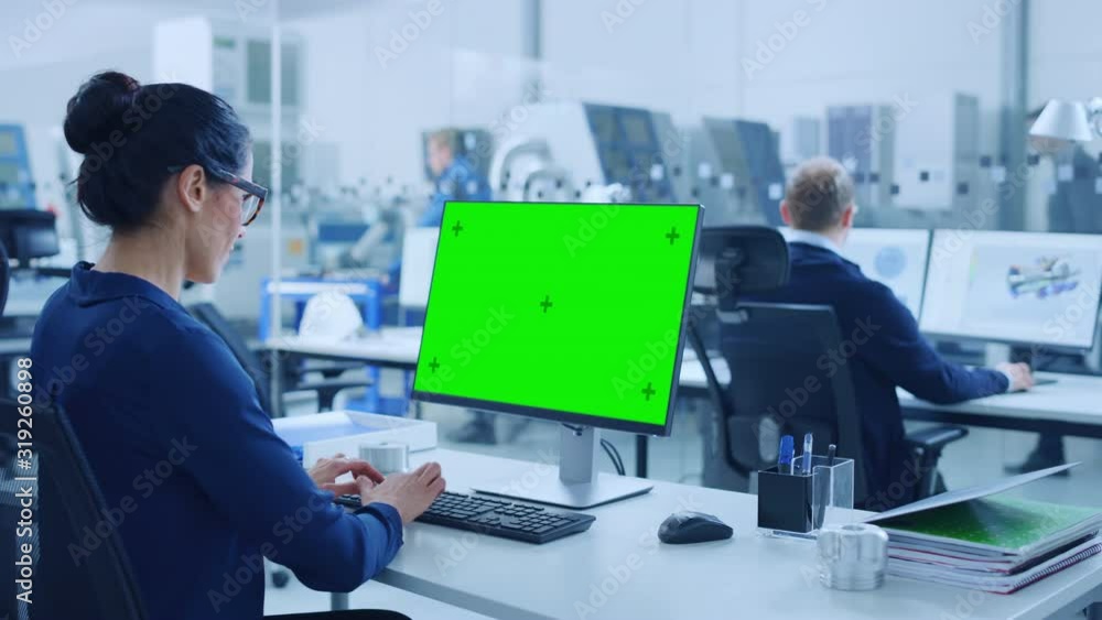 Aufkleber over the shoulder: female chief engineer working on personal computer, display is green mock-up scre