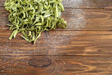 Pasta, vegetables, herbs and spices, olive oil, ingredients for Italian cuisine on a wooden brown background.