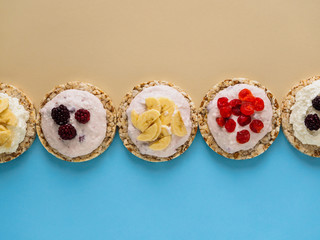 Dessert on blue and yellow background. Crispbread, cottage cheese and fruit