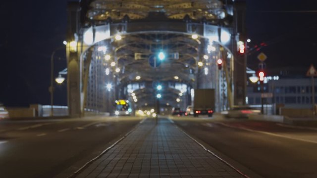 Timelapse of different cars driving along road at nighttime. City illuminated with lights