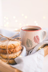 Fresh cookies and cup of tea on a wooden tray.