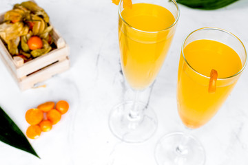 cocktail with physalis in glass on stone background