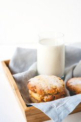 Stacked cookies on a linen napkin and a glass of milk.