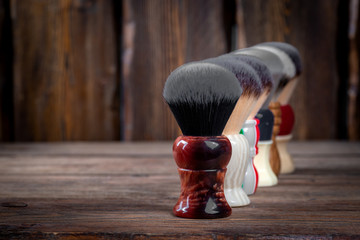 soft shaving brushes on rustic wooden boards background, barber shop concept