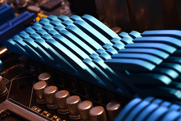 Detail of a blue aluminum heatsink on a modern pc motherboard. selective focus.
