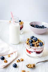 Cooking breakfast with granola and berries on white kitchen background