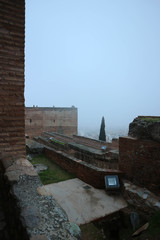 Fototapeta na wymiar Inside view of old medieval citadel of Alhambra, Granada, Spain in the morning fog