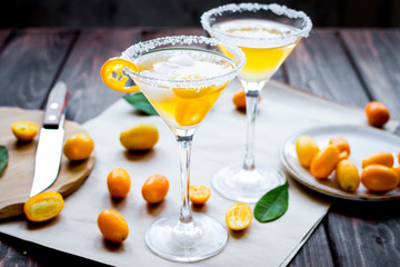 cocktail with kumquat on wooden background
