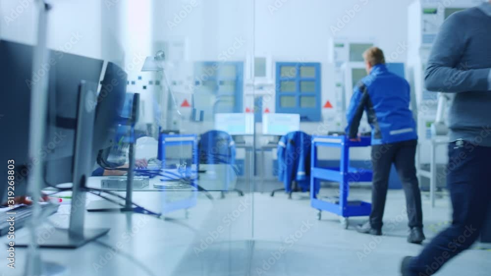 Poster inside factory glass office team of industrial engineers working on pc, outside cubicle in the moder