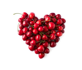 Heart shape red cherries on white background. Background made of cherry. Sweet cherry isolated on white background cutout. Various summer berries. Ripe cherries hill isolated on white. Top view.
