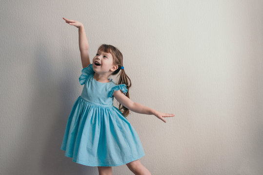 Pretty little girl dancing in blue dress