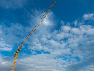 Cranes for construction and lifting loads for renovation or construction of buildings and blue sky with clouds