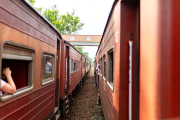 People communicate from the windows of various trains stopped at the station