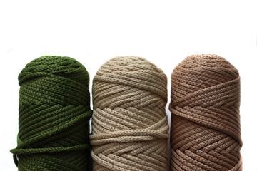 three skeins of cord for needlework. skeins of beige, dairy and green colors. Of them knit carpets, accessories, decor for the interior, etc.