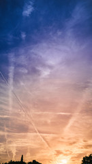 Plane condensation trails on sunset sky of Barcelona city, Spain 