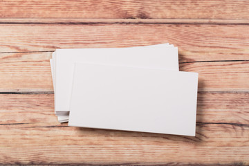 Photo of empty business cards on a light natural wooden background .. Template for identifier.