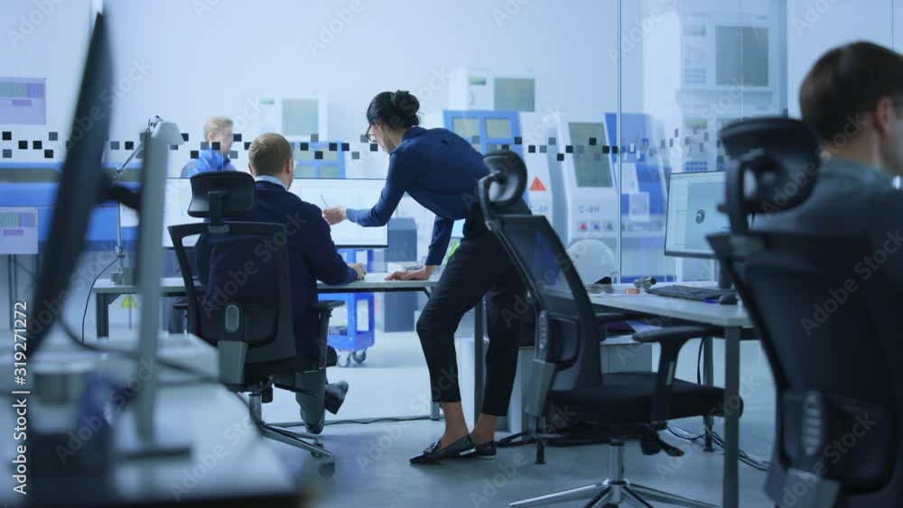 Poster modern factory: female project supervisor talks to a male industrial engineer who works on computer.
