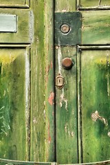 Old wooden green door with wrought iron details