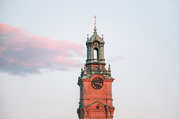 The Royal Palace clock tower in sky at sunset in Stockholm 