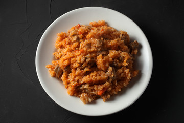 pilaf on a white plate, dark background