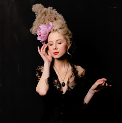 Beautiful blonde countess with vintage hairstyle and corset