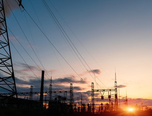 The silhouette of the evening electricity transmission pylon. Power transmission from a power plant to a city.