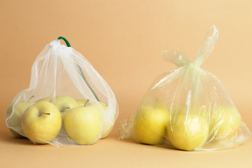 Eco-friendly zero waste fruit bag and plastic bag together. hand. Apple inside.