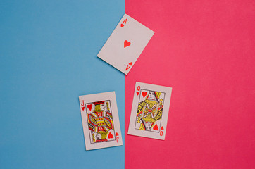 Cards - Ace, Queen and Jack of Hearts on pink-blue background. The concept of relations of man and woman, psychology of relations, love. Valentine's Day.