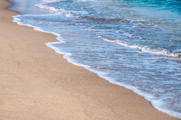 Seascape. Waves running on the sandy shore. Shore of the sea or ocean on a nice day. Vacation and relaxation by the sea.