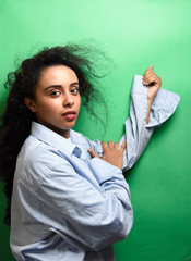 Spectacular middle eastern young woman with her black hair. Indoor photo of wonderful female model on green background.