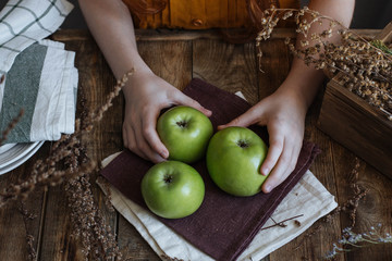 Three green apples on a wooden table