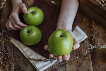 Three green apples on a wooden table