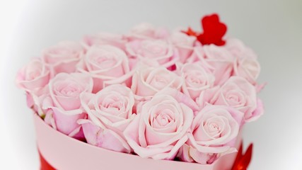 Beautiful valentiens day floral arrangement. Pink roses with read hearts flower composition in a box.