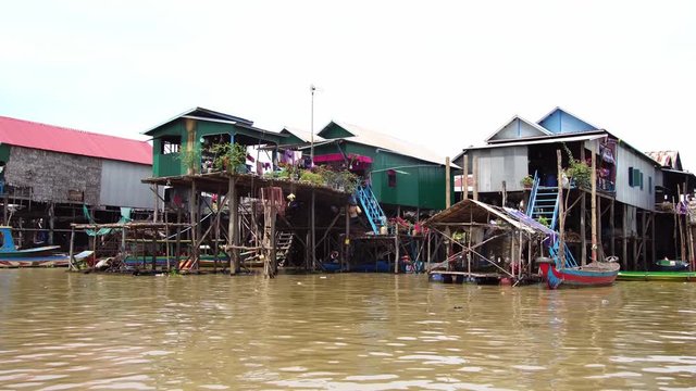 Floating village in Siem Reap, Cambodia. Traditional stilt houses on water. Tonle Sap lake boat trip for backpackers & tourists.