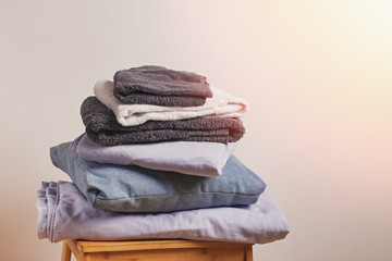 A stack of linen textiles on a small wooden chair