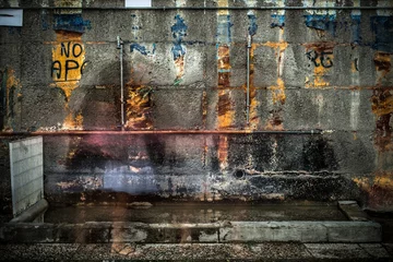 Foto op Canvas Oude verroeste muur met bedekte graffiti © Cristi Serban/Wirestock