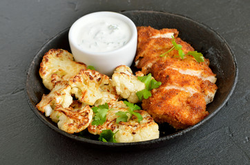 Chicken breast, fried cauliflower and sauce on plate