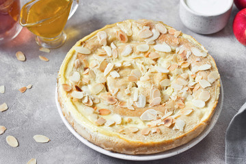 Baked cottage cheese crepes cake with almond and sour cream. Traditional Maslenitsa (Shrovetide) meal on gray background.