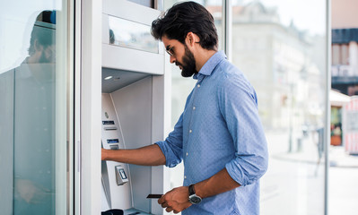 Man using an cash dispenser on the street