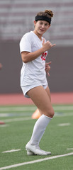 Young athletic girl playing soccer in a game