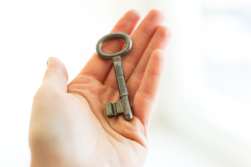 Old key in womans hand, The concept of buying a new home or sold house